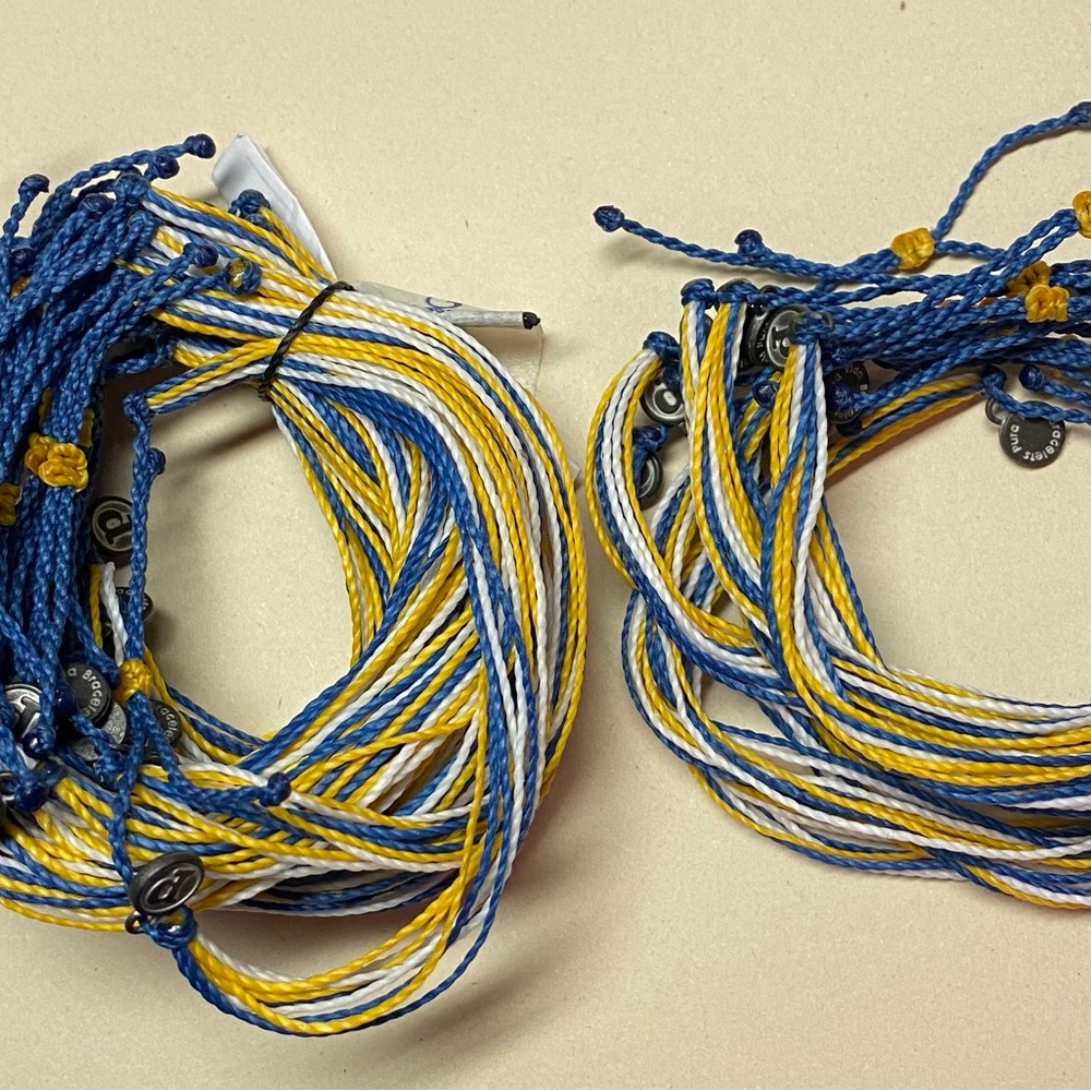 35 Brand New Pura Vida bracelets comprised of yellow, white and blue strings.